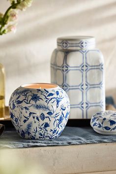 blue and white vases sitting on top of a table next to other decorative items