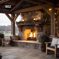 an outdoor fireplace is lit up with christmas lights on the top and below it's mantle