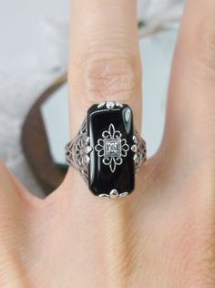 Black Glass/Stone & CZ Ring Grace Design#233 Custom Made I now offer this lovely Antique Art Deco/Edwardian design ring in sterling silver. This gorgeous ring is set with a stunning floral filigree embellished black glass/resin with a centered set 1mm white CZ. The Black glass is 18mm Long by 19mm Wide. The ring sits 19mm NS in the finger and 10mm EW on the finger. The inside of the band is marked 925 for sterling. Notice the beautiful leaf geometric design of the filigree band and setting. Antique Jewelry With Gemstone Accents For Formal Occasions, Classic Formal Jewelry With Stone Setting, Vintage Cubic Zirconia Gemstone Jewelry, Art Deco Jewelry Ring With Gemstone Accents, Victorian Rings With Stone Setting For Formal Occasion, Antique Jewelry With Gemstone Accents For Wedding, Antique Gemstone Accent Jewelry For Weddings, Art Deco Ring With Gemstone Accents, Art Deco Diamond Jewelry With Gemstone