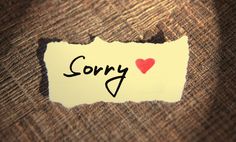 a piece of paper with the word sorry written on it and a red heart in the center