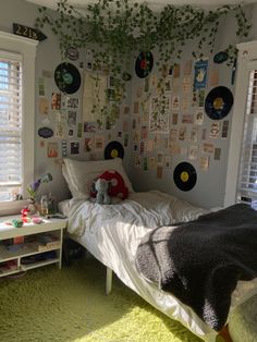 a bedroom with green carpet and lots of pictures on the wall