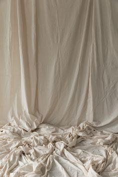 an unmade bed with white sheets on it