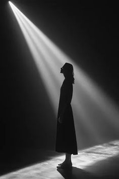 a woman is standing in the dark with light coming from her head