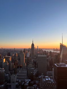 the sun is setting over new york's skyline as seen from top of the rock