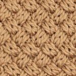 close up view of the crochet stitchs on a beige fabric textured with wool