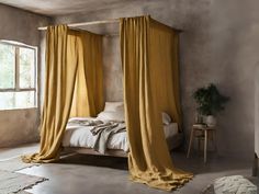 a bed with yellow drapes in a bedroom next to a window and rugs on the floor