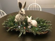 two white rabbits sitting on top of a table