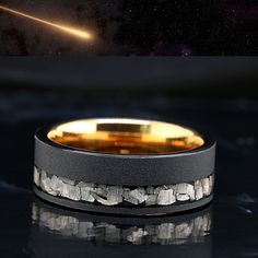 an image of a wedding ring with rocks in the middle and a space background behind it