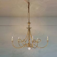 a chandelier hanging from the ceiling in a room with white walls and flooring