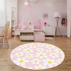 a pink and yellow room with white furniture and flowers on the round rug in the middle