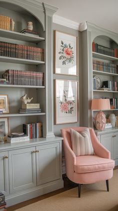 a pink chair sitting in front of a book shelf filled with books