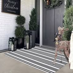 a black and white striped door mat with a deer statue on it's side