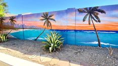 this is an image of a beach scene painted on the side of a building with palm trees