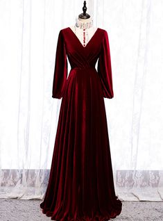 This dress is a mix of Victorian and modern. The burgundy dress has a white ruffled high neck that gives it a Victorian look, the neckline is further bedecked with red buttons that complement the white base of the dress. Long velvet sleeves have a style statement making look. The deign of the dress is such that it accentuates the curvatures of your figure and make it look even more beautiful. The skirt extends from the waistline to the floor. The whole dress is a sight to behold and mesmerizes the onlookers. The back of the dress has a v plunge and a zip at the back that completes the look of the dress. High Neck Long Sleeve Prom Dress, डिजाइनर कपड़े, Simple Bridesmaid Dresses, Fancy Fashion, V Neck Prom Dresses, Dream Prom, Red Velvet Dress, Burgundy Bridesmaid Dresses, Long Sleeve Prom