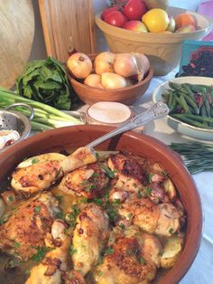 a bowl filled with chicken and vegetables on top of a table next to other bowls