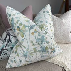 three pillows on a couch with different patterns