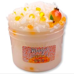 a plastic container filled with rice and jelly beans next to an orange apple on top