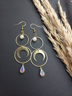 Moon earrings with iridescent rhinestones and white pearls and also available an option with drop crystal beads in Opal white color. . Made of raw brass parts, drop shaped crystals and glass pearls. No Nickel and no Lead. . When the little crystal drops moving they reflect light blue and light purple shades. . Light to wear and easy to combine. 🌿 . The item will arrive to you wrapped as a gift in a little paper gift bag. . 》SHIPPING: If you need a tracking number for your order change the shipp Metal Moon Phase Jewelry For Parties, Wedding Crystal Pearl Drop Earrings, White Moon Charm Jewelry For Party, White Moon Charm Party Jewelry, White Party Jewelry With Moon Charm, Celestial Style Dangle Jewelry For Wedding, Iridescent Jewelry With Matching Earrings For Wedding, Iridescent Pearl Drop Jewelry For Wedding, Iridescent Celestial Dangle Jewelry