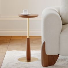 a white chair with a wooden table next to it on top of a carpeted floor