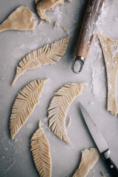 some food is laying out on a table next to a knife and cookie cutters