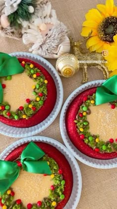 three red plates with green and yellow decorations on them next to a sunflower bouquet