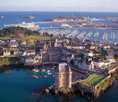 an aerial view of a city with boats in the water and lots of buildings around it