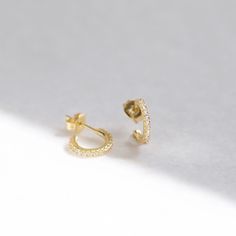 "These tiny open-hoop stud earrings are adorned with brilliant cubic zirconia gemstones. They're the perfect huggie hoop size for layering with other dainty hoops and studs. A dainty, elegant and versatile addition to your everyday lineup. ∙ Sold as a PAIR * D E T A I L S * ∙ Material: .925 Sterling Silver or 18K Gold Plated over .925 Sterling Silver ∙ Stone: White Cubic Zirconia ∙ Dimensions: Outer diameter: 11mm // Inner diameter: 7mm ∙ Hypoallergenic & nickel-free * P A C K A G I N G * ∙ Small Hoop Piercings For Anniversary, Everyday Drop Huggie Earrings With Prong Setting, Everyday Small Hoop Earrings With Prong Setting, Small Hoop Cubic Zirconia Cartilage Earrings For Anniversary, Cubic Zirconia Huggie Diamond Earrings For Gift, Minimalist Tarnish Resistant Cubic Zirconia Hoop Earrings, Small Hoop Cartilage Earrings With Prong Setting As Gift, Small Hoop Huggie Earrings With Prong Setting As Gift, Cubic Zirconia Huggie Hoop Earrings For Pierced Ears