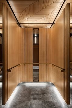 an empty room with wooden partitions and lights on the ceiling, along with concrete flooring