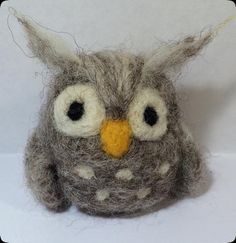 an owl ornament made out of wool with eyes wide open and nose wide