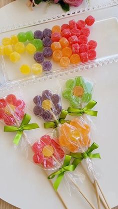 candy lollipops in cello bags on a table next to flowers and a vase