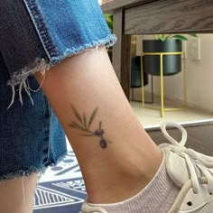 a woman's foot with a small flower tattoo on her left side ribcage