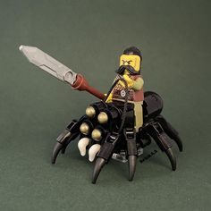 a lego man holding a knife in front of a spider with his legs spread out