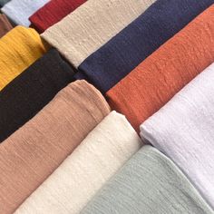 many colors of towels are lined up together