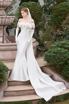 a woman in a white wedding dress standing on steps