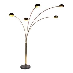 a floor lamp with five lights on it and three lamps in the middle, all turned on