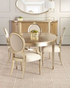 a dining room table with chairs and a round mirror