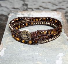 Triple wrap bracelet with 4mm Tiger Eye faceted round beads and brass hex beads hand-strung on leather cord and finished with a bee button. Triple Wrap Bracelet, Charleston Sc, Leather Cord, Tiger Eye, Round Beads, Tigers, Wrap Bracelet, Bee, Brass