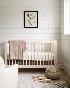 a baby's room with white walls and wood floors