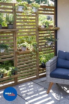 a chair sitting on top of a patio next to a wooden fence with plants growing in it