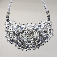 This silver statement necklace is the biggest and most extravagant textile necklace. A collier femme is made for a special occasion. Abstract shape filled with small circles and ribbon layers creates a new look and exclusive fiber artwork piece. At least the graphite grey and pearl color beads as a final touch were added. I created this original statement necklace using my beloved grey, silver, and white colors which add a waft of elegance and chick. This fiber art jewelry piece is a perfect gif Unique Silver Beads Necklace, Handmade Silver Necklace In Wearable Art Style, Handmade Silver Beaded Necklaces For Evening, Silver Handmade Beaded Necklaces For Evening, Elegant Handmade Metal Bib Necklaces, Elegant Handmade Metal Bib Necklace, Handmade Silver Beaded Necklaces For Party, Silver Bib Necklace Choker For Evening, Handmade Metal Bib Necklace For Party