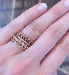 a close up of a person's hand with three rings on their fingers and one ring in the middle