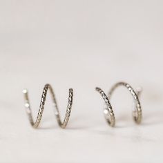 Tiny Double Hoop Earrings, Minimal Spiral Earrings, Tiny Twist Earrings, Double Hoop Earrings, Double Piercing, Diamond Cut Hoop EarringsTwist these little coils in and instantly get the appearance of two lobe piercings.(You only need ONE piercing to make these work-- they give the look of two!)(It can also be worn with two holes in case you have them)All you do is thread one side through your first hoop until the other side sits comfortably on your earlobe giving the illusion of a second hole. Metal Spiral Wrap Single Earring, Silver Spiral Wrap Earrings, Pierced, Metal Spiral Wrap Earrings, Spiral Metal Wrap Earrings, Silver Spiral Cartilage Earrings As Gift, Minimalist Spiral Hoop Earrings For Pierced Ears, Adjustable Silver Spiral Cartilage Earrings, Silver Spiral Hoop Earrings For Everyday, Everyday Spiral Silver Hoop Earrings