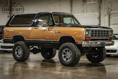 an orange pick up truck parked in a garage