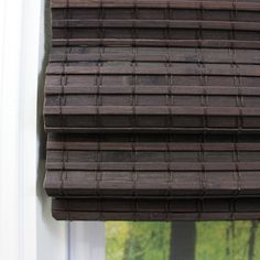 a cat sitting on top of a window sill next to a window with blinds