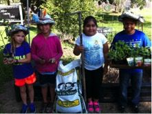 four children are holding plants in their hands