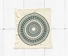 a tea towel hanging on a wall with a circular design in black and white colors