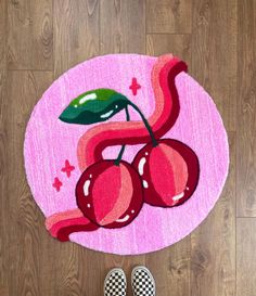 a pink rug with two cherries on it