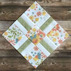 a piece of fabric that is on top of a wooden surface with flowers and leaves