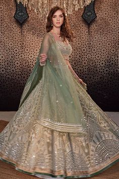 Jade green lehenga with mirror, thread, pearl and bead embroidery and attached cancan. Paired with a pearl and stone embroidered padded blouse with tasseled hem and embroidered organza dupatta.
Components: 3
Pattern: Embroidered
Type Of Work: Hand and Machine
Neckline: Sweetheart
Sleeve Type: Sleeveless
Fabric: Organza
Color: Green
Other Details: 
Model Height: 5ft 8inches, wearing size XS
Lehenga length: 44 inches
Occasion: Wedding - Aza Fashions Green Lehenga With Cutdana For Reception, Green Sharara With Gota Work For Reception, Pista Green Sharara With Gota Work For Reception, Green Cutdana Sharara For Wedding, Pista Green Lehenga With Cutdana For Designer Wear, Pista Green Lehenga With Cutdana Detail, Designer Pista Green Lehenga With Cutdana, Pista Green Dupatta With Gota Work For Reception, Pista Green Lehenga With Cutdana For Eid