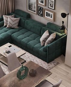 a living room with green couches and pictures on the wall above it's coffee table